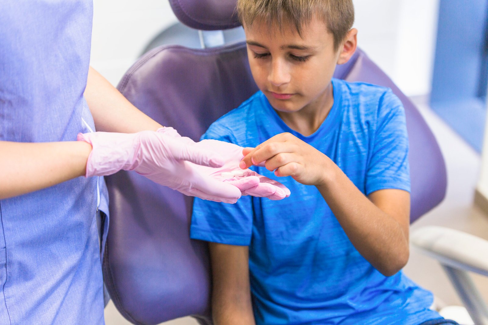 child-patient-taking-medicine-from-female-dentist-hand